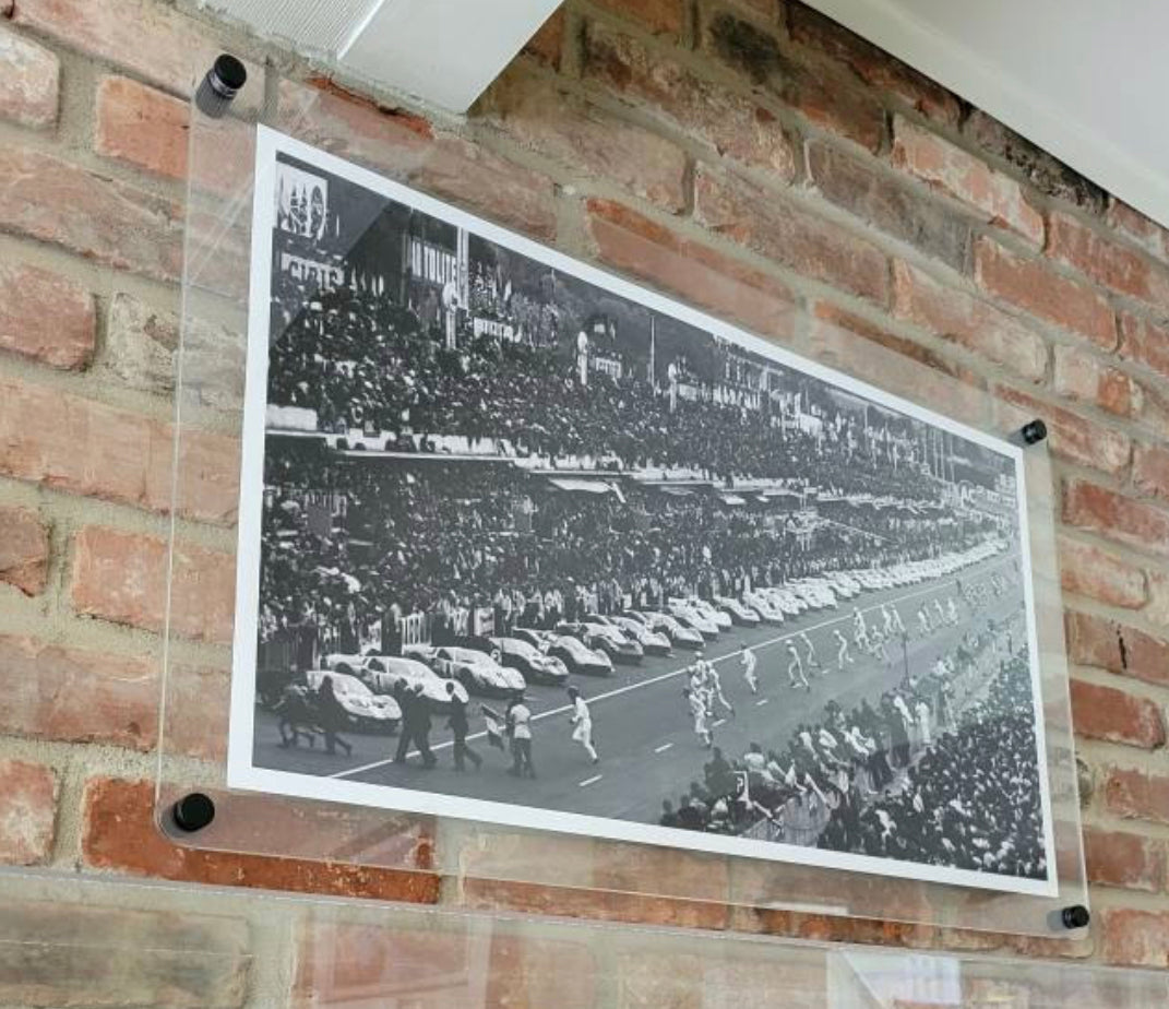 Clear floating acrylic picture frame holding a black and white panoramic photo on a brick wall