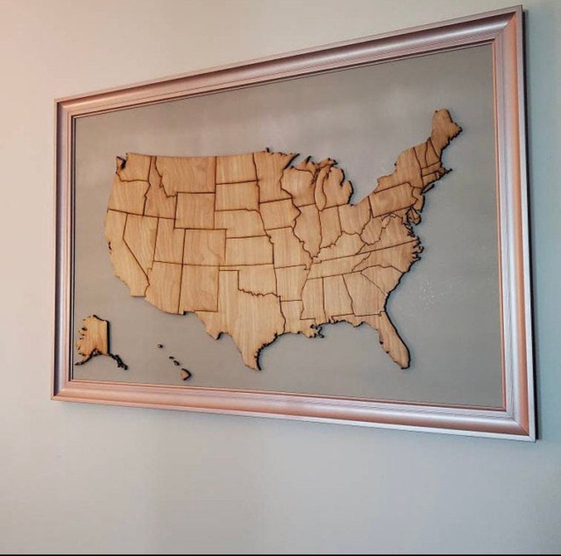 Wooden USA map cutout wall art with individually cut state pieces mounted in a copper frame